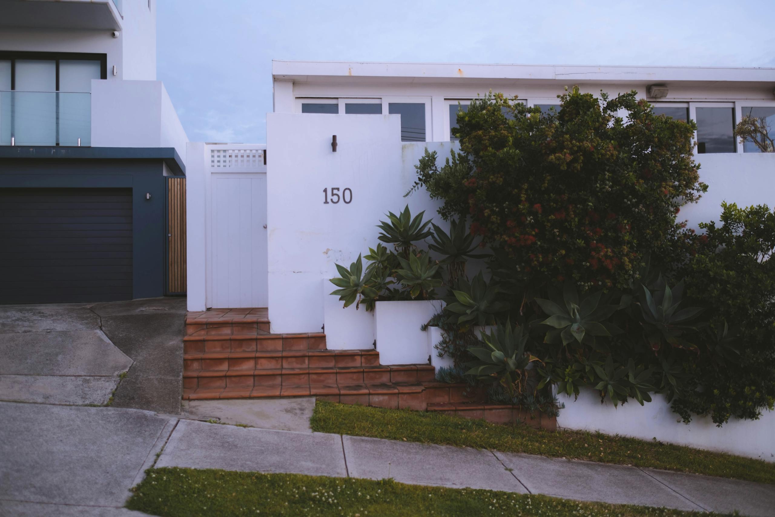 Modern house facade decorated with lush vegetation in town